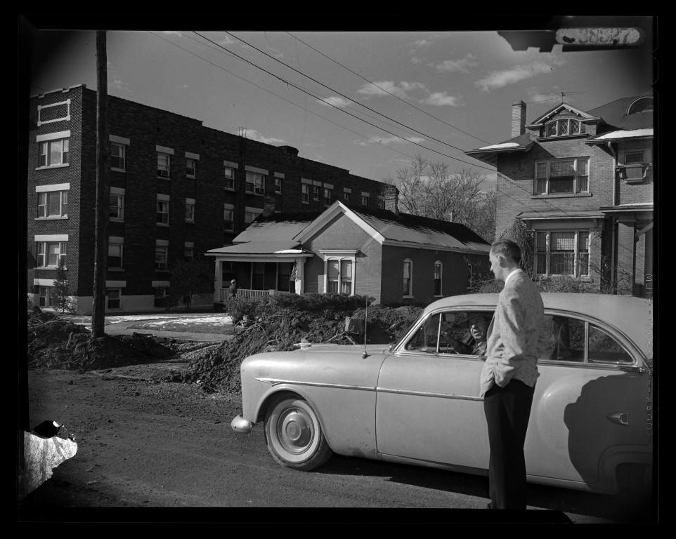 A man and automobile beside construction on 700 East in 1956