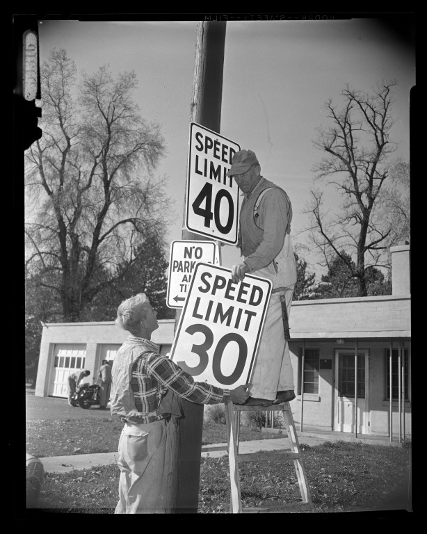 Workers changing a speed limit sign from 30 to 40 miles per hour on Seventh East in 1959